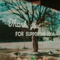 Shop window sign supporting local, illustrating marketing ideas for small business