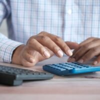 Business owner using a calculator to compare affordable SEO packages and monthly costs